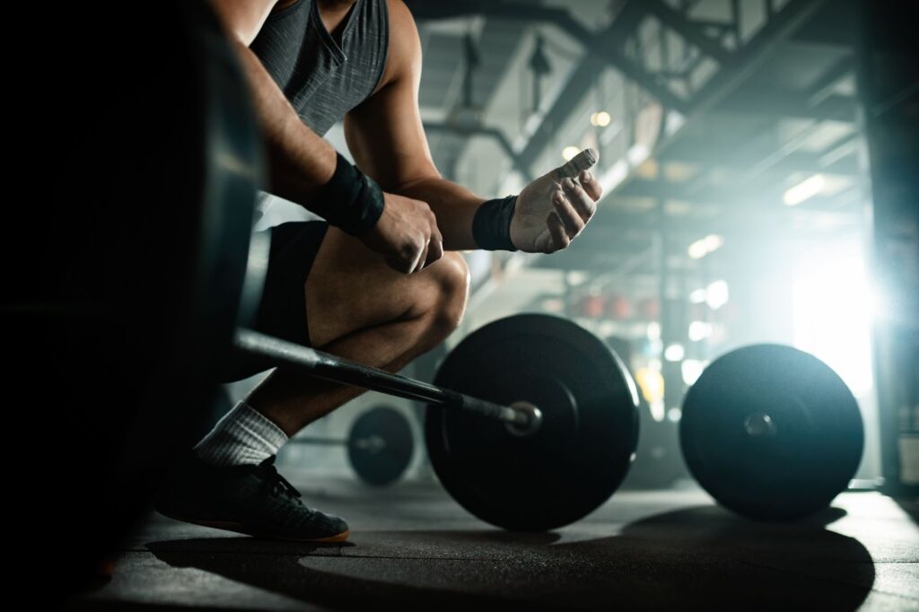 Low angle view of muscular build man preparing for lifting a barbell